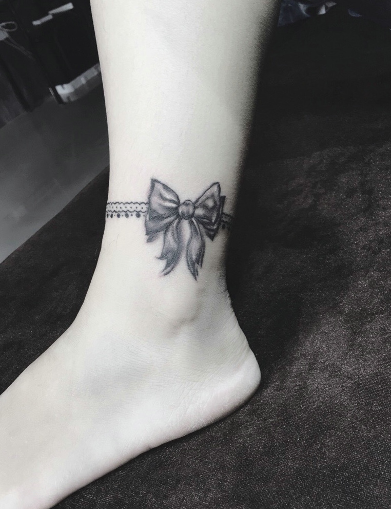 点击大图看下一张：脚腕上的黑灰蝴蝶结纹身图片很优美