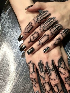 黑色指甲搭配着黑色花体纹身图案