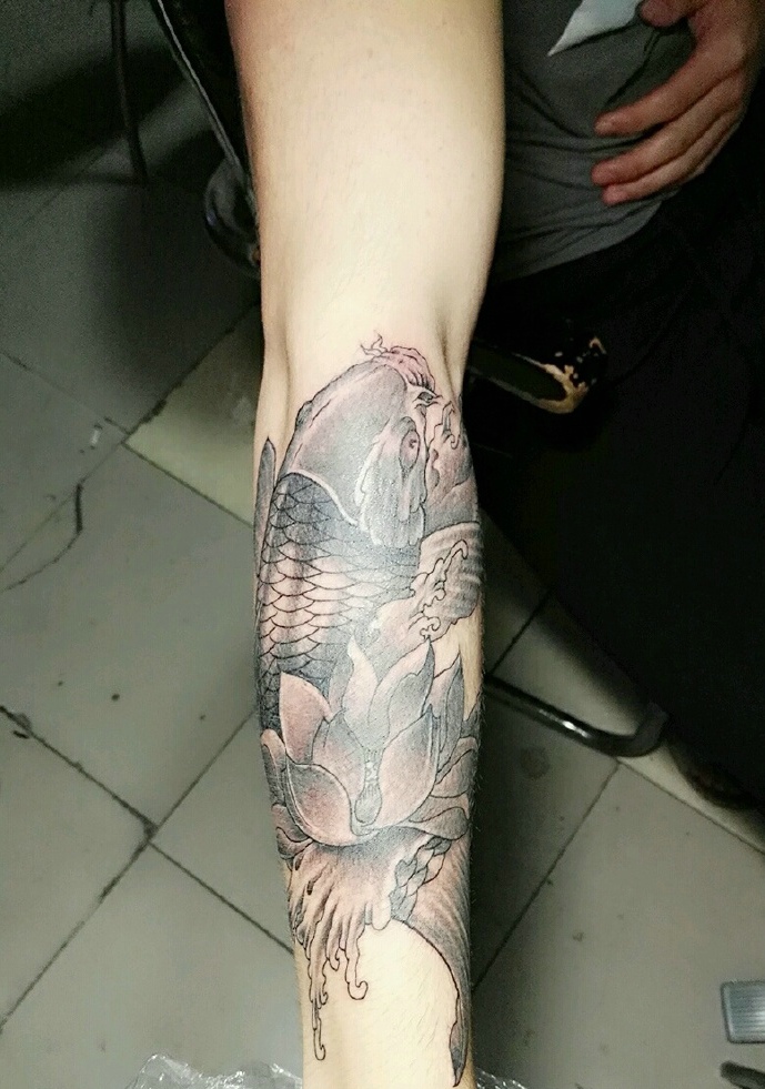 点击大图看下一张：莲花与鲤鱼结合的手臂纹身图案
