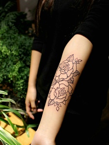 黑衣女子手臂黑白花朵纹身图案