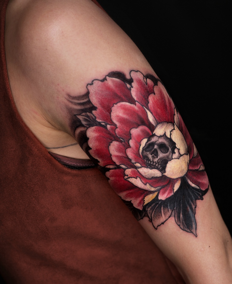 点击大图看下一张：手臂被花包围着的骷髅纹身图案