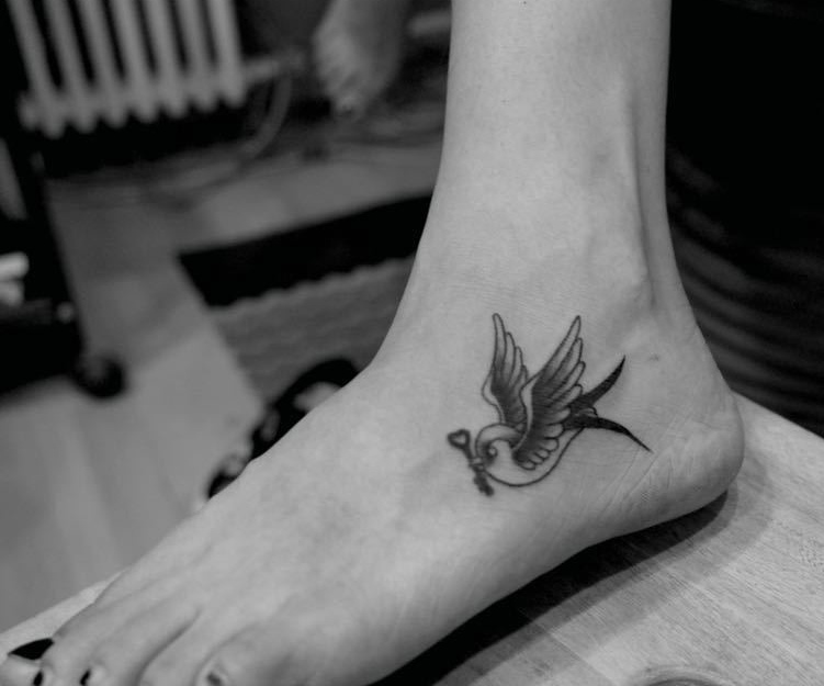 点击大图看下一张：处在脚背上的一只小燕子纹身图案