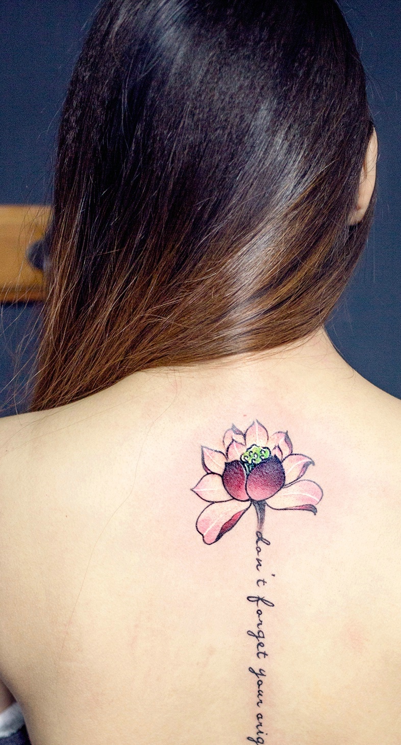 点击大图看下一张：莲花与英文一起的脊椎部纹身刺青