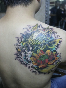 遮盖后背一小部分的莲花鲤鱼纹身图案