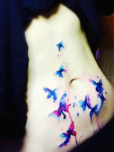 女生腹部上的水彩纹身图案很绚丽
