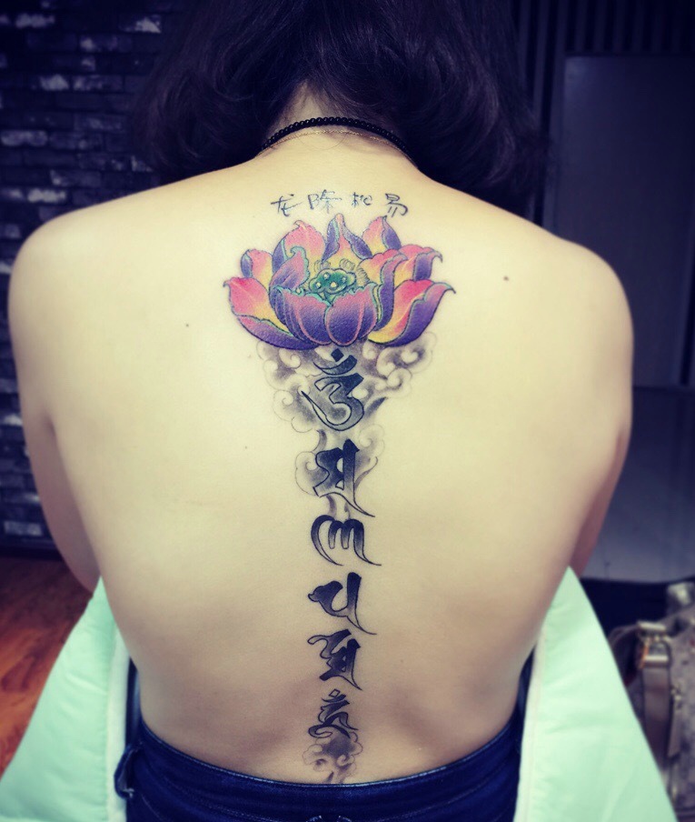 点击大图看下一张：彩色莲花与梵文结合的脊椎部纹身图案