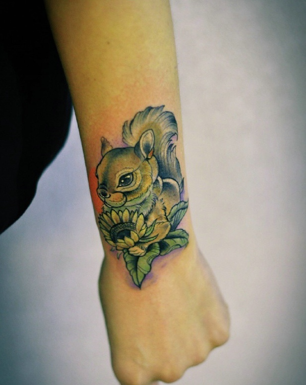 点击大图看下一张：捧着向日葵的小松鼠手臂纹身图案