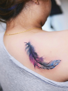 女生后背一片色彩迷人的羽毛纹身图案