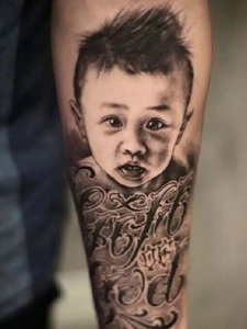 英文与小男孩肖像的手臂纹身图案