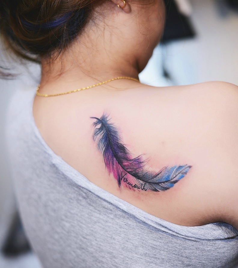 点击大图看下一张：女生后背一片色彩迷人的羽毛纹身图案