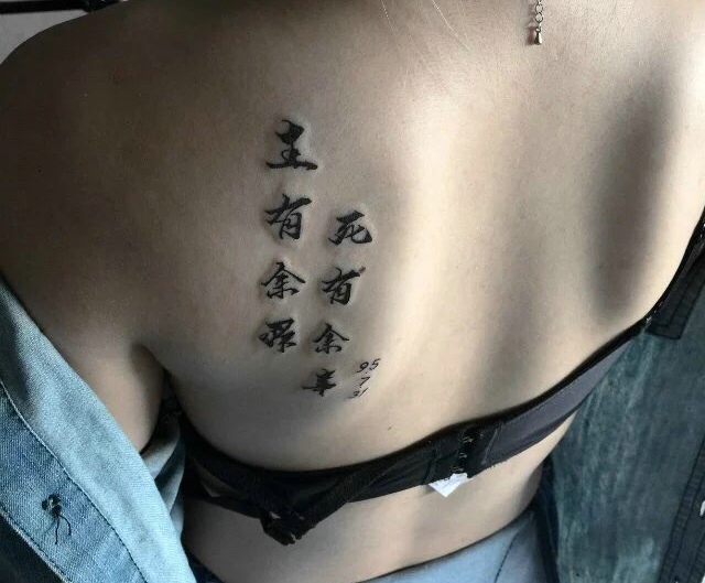 点击大图看下一张：个性女孩后背有着个性的汉字纹身图案