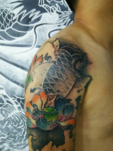 大臂莲花与鲤鱼结合的纹身刺青