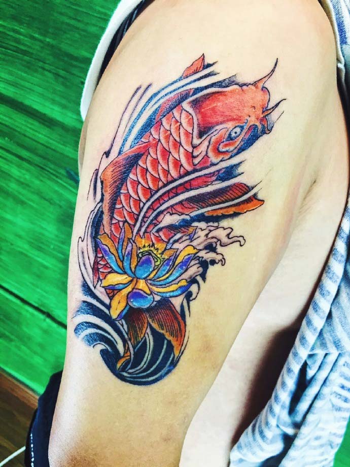 点击大图看下一张：莲花与红鲤鱼结合的花臂纹身图案