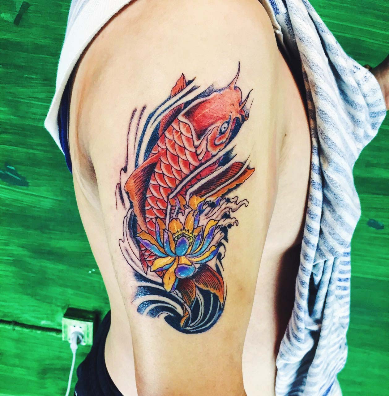 点击大图看下一张：莲花与红鲤鱼结合的花臂纹身图案