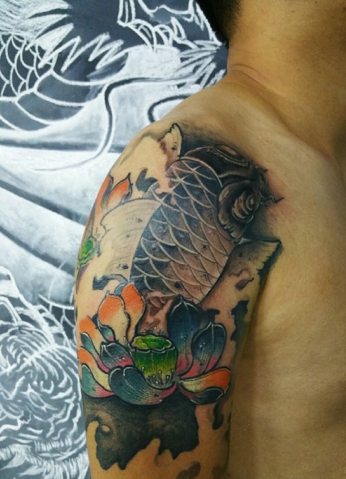 点击大图看下一张：大臂莲花与鲤鱼结合的纹身刺青