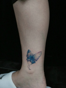 裸脚侧边上的彩色蝴蝶纹身图案