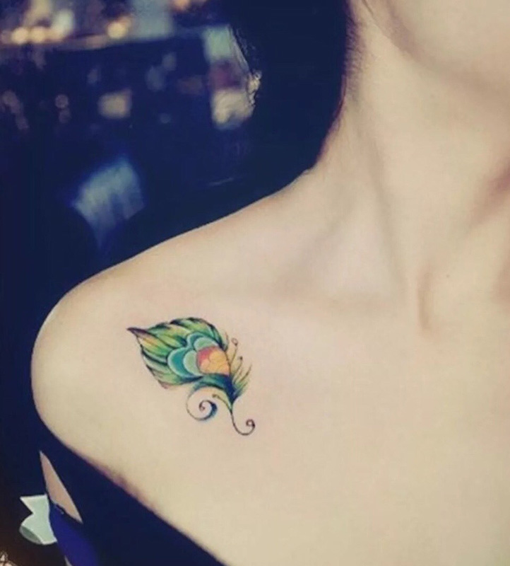 点击大图看下一张：锁骨处美丽的孔雀羽毛纹身