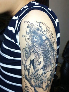 莲花与鲤鱼结合的大臂纹身图案