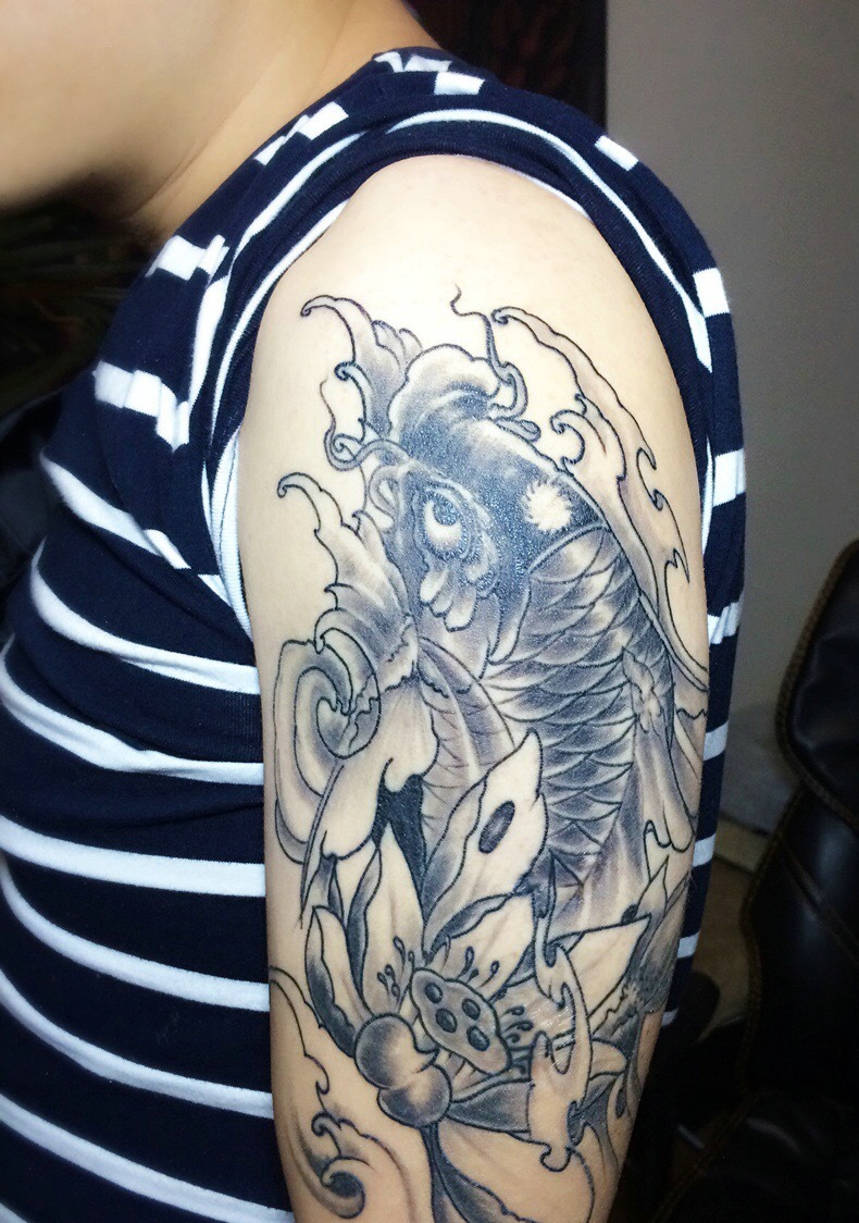 点击大图看下一张：莲花与鲤鱼结合的大臂纹身图案