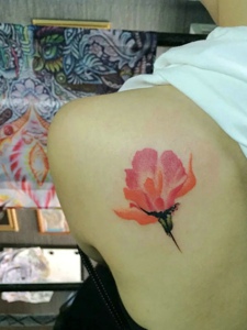 女生后背一只艳丽的花朵纹身图案