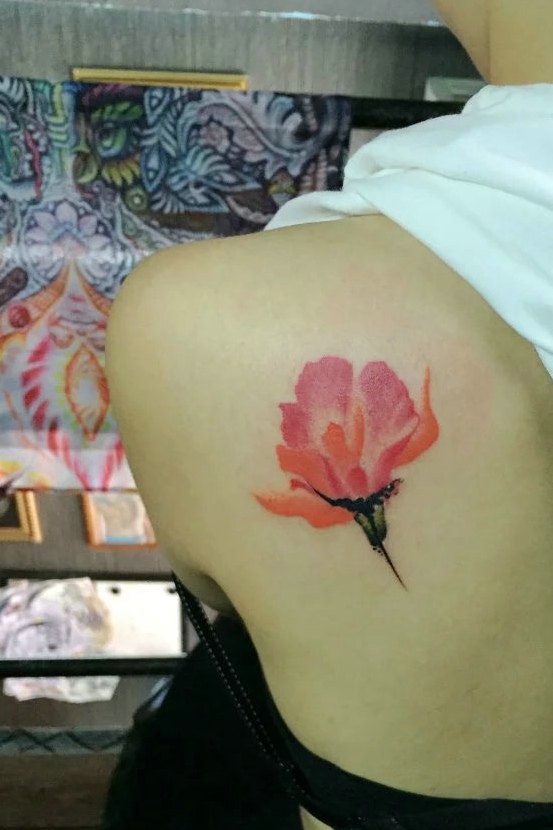 点击大图看下一张：女生后背一只艳丽的花朵纹身图案