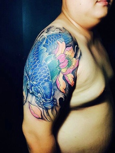 莲花与蓝鲤鱼结合的大臂纹身图案
