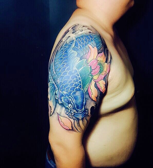 点击大图看下一张：莲花与蓝鲤鱼结合的大臂纹身图案
