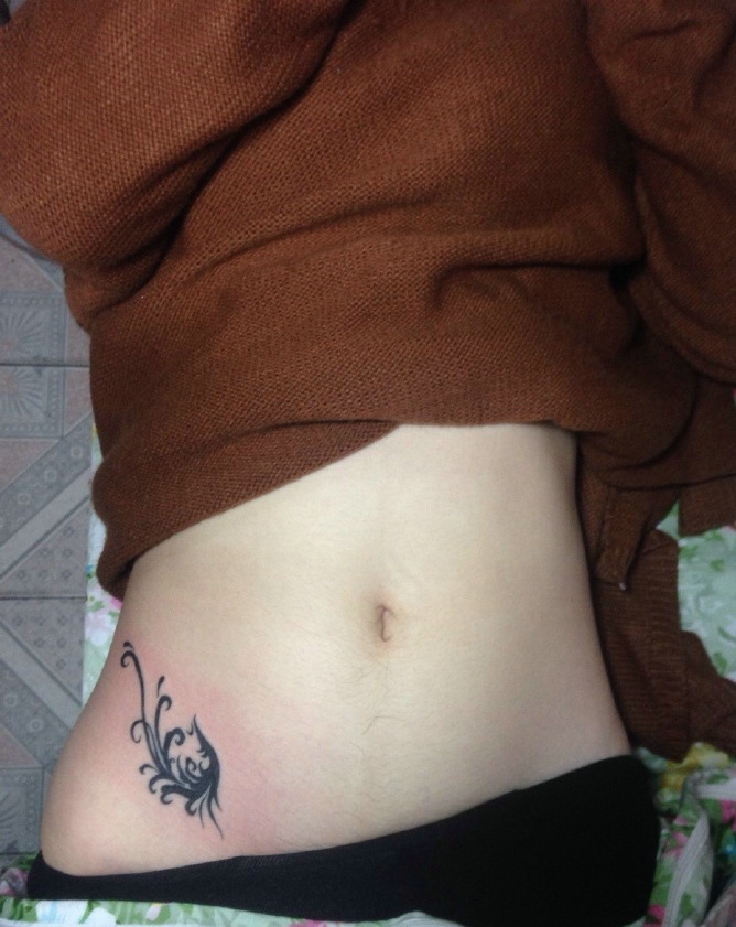 点击大图看下一张：落在女生腰部小测的小图案纹身