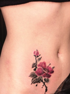 处在女生腹部上的梅花纹身图案