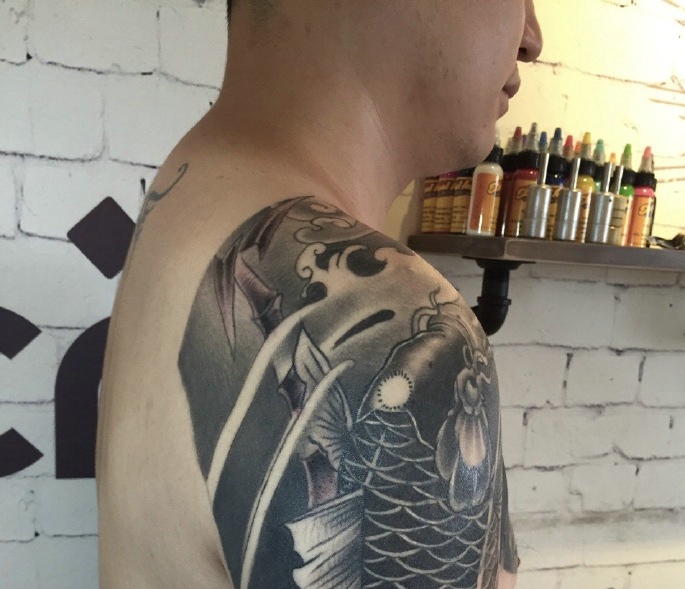 点击大图看下一张：大臂与胸前连在一起的鲤鱼纹身图案