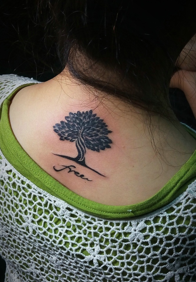 点击大图看下一张：脖子后部一颗精致的小树纹身图案