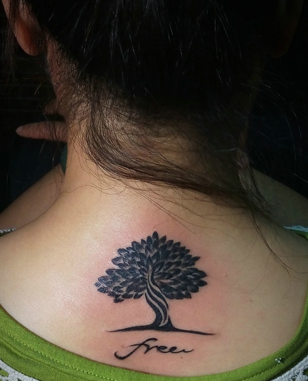 点击大图看下一张：脖子后部一颗精致的小树纹身图案