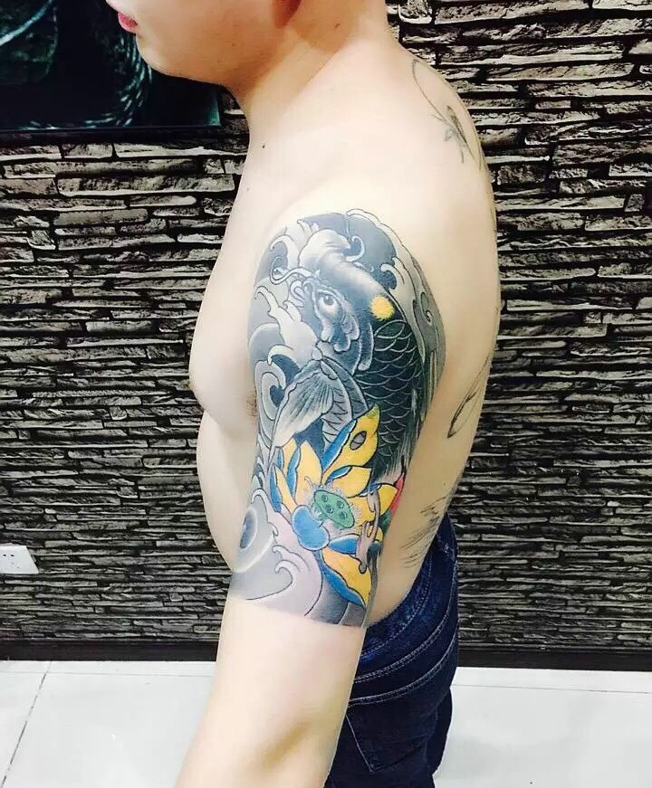 点击大图看下一张：莲花与鲤鱼结合的大臂纹身刺青