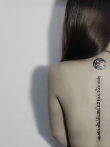 时尚女孩脊椎部一条梵文纹身图案