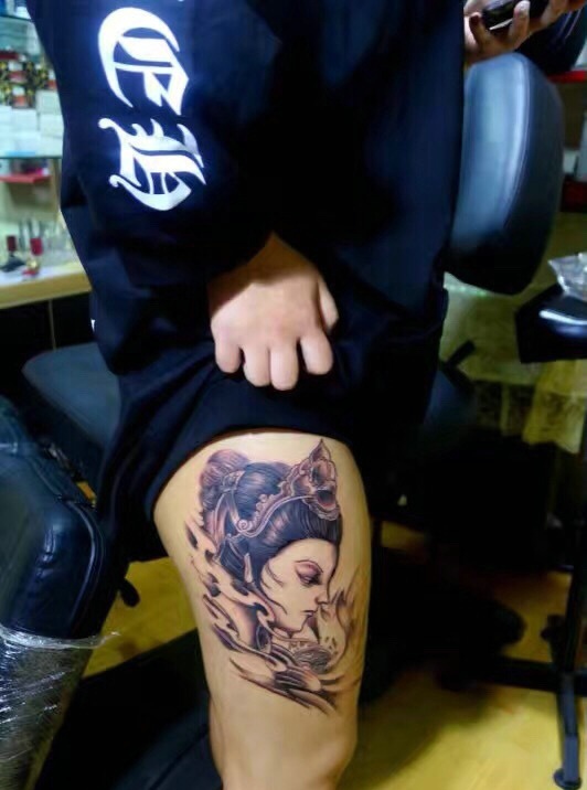 点击大图看下一张：大腿外侧一枚精致的花妓纹身图案