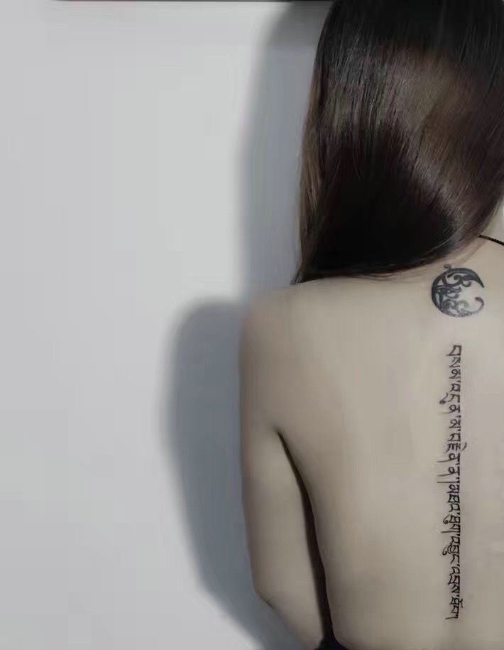 点击大图看下一张：时尚女孩脊椎部一条梵文纹身图案