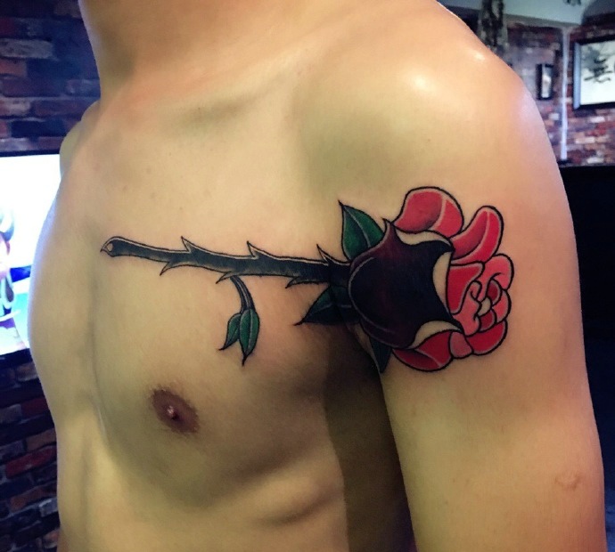 点击大图看下一张：个性男孩配着一朵玫瑰纹身图案