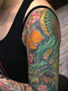 遮盖花臂的一条彩色邪龙纹身图案