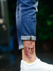 可爱小狗头像与花朵一起的腿部纹身图案