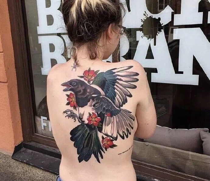 点击大图看下一张：女生晳白的后背一只彩色乌鸦纹身图案