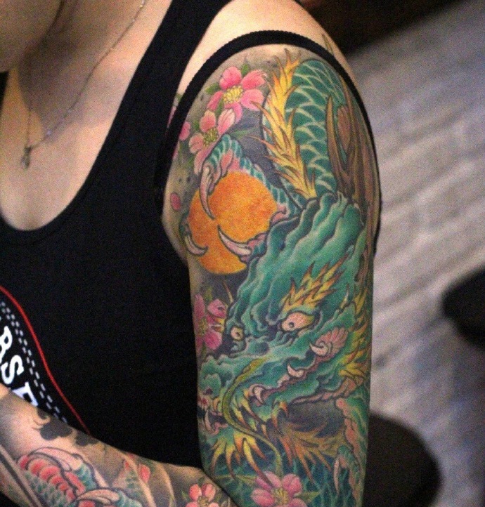 点击大图看下一张：遮盖花臂的一条彩色邪龙纹身图案