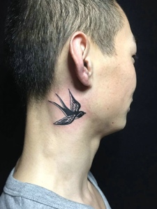 飞在男士耳边上的一只小鸟纹身图案