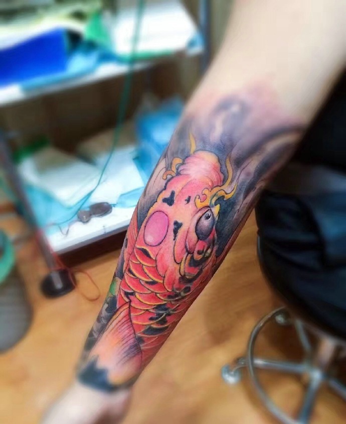 点击大图看下一张：惊艳动人的手臂红鲤鱼纹身图案