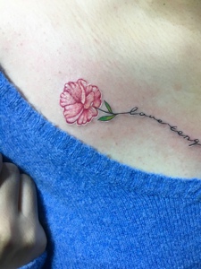 女生锁骨处一枝花与英文纹身图案