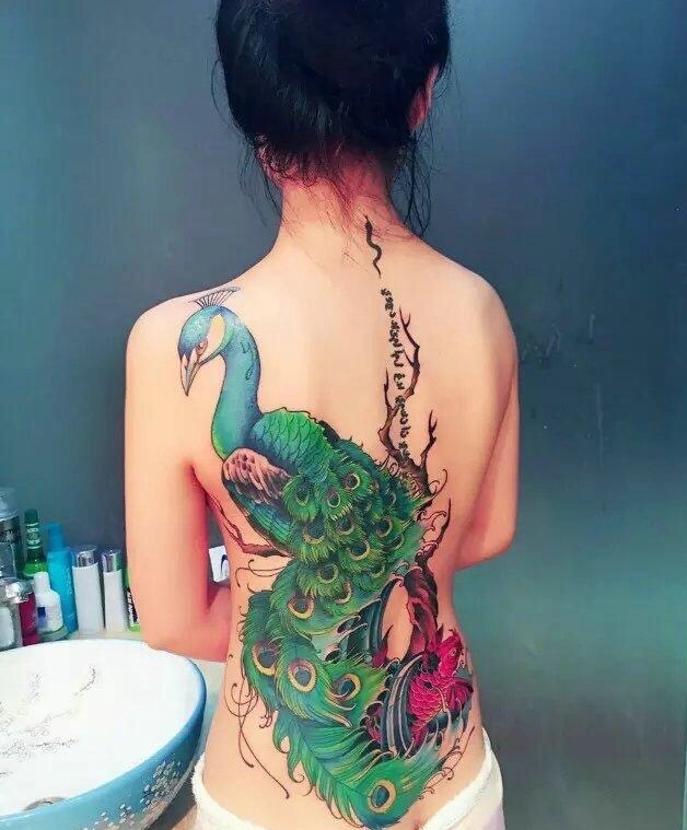 点击大图看下一张：女生后背骄傲狂大的孔雀纹身图案