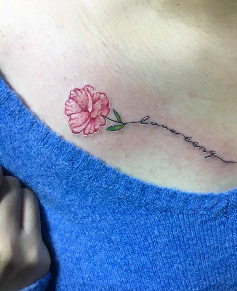 点击大图看下一张：女生锁骨处一枝花与英文纹身图案