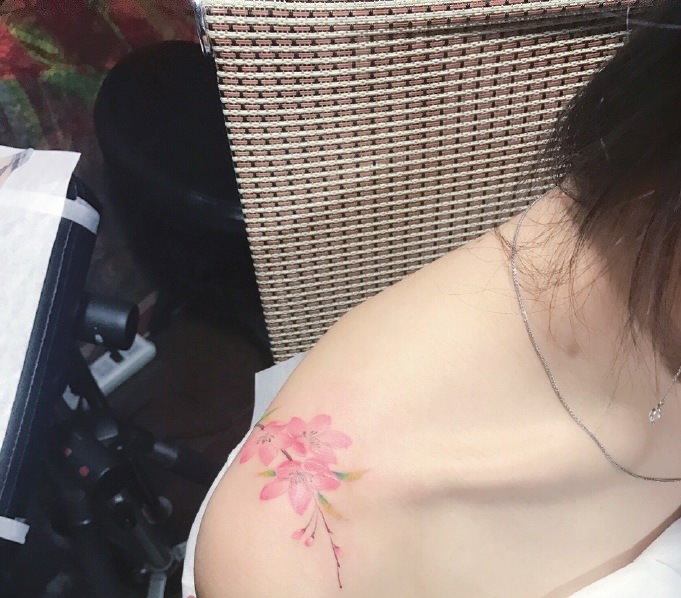 点击大图看下一张：晳白肌肤香肩上的小樱花纹身图案