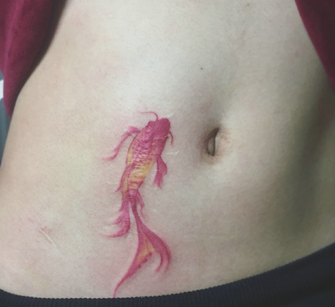 点击大图看下一张：游在女生肚脐边上的小金鱼纹身图案